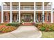 Inviting front porch with double doors, brick columns, seating, and colorful flower pots adding warmth and charm at 1100 Muirfield Ct, Alpharetta, GA 30005