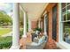 Spacious porch with brick flooring, white columns, and outdoor seating perfect for enjoying the outdoors at 1100 Muirfield Ct, Alpharetta, GA 30005