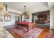 Entertaining game room with pool table, stone fireplace, and bar area in the background at 1100 Muirfield Ct, Alpharetta, GA 30005