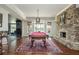 Bright game room with a pool table, stone fireplace, and scenic views from the windows at 1100 Muirfield Ct, Alpharetta, GA 30005