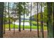 Scenic view of the golf course and lake through the trees offering serene views and natural beauty at 1100 Muirfield Ct, Alpharetta, GA 30005