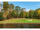 Picturesque view of the golf course near the lake, featuring lush green fairways and mature trees at 1100 Muirfield Ct, Alpharetta, GA 30005