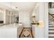 Elegant kitchen with a large island, white cabinetry, and a view of the staircase at 1100 Muirfield Ct, Alpharetta, GA 30005