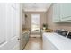Well-lit laundry room with modern appliances, ample counter space, and stylish light-green cabinetry at 1100 Muirfield Ct, Alpharetta, GA 30005