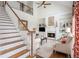 Open concept living room with a fireplace, ceiling fan, and staircase in the background at 1100 Muirfield Ct, Alpharetta, GA 30005
