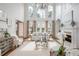 Bright living room with high ceilings, large windows, fireplace, and elegant chandelier at 1100 Muirfield Ct, Alpharetta, GA 30005