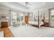 Spacious main bedroom with tray ceiling, four-poster bed, sitting area, and large windows offering natural light at 1100 Muirfield Ct, Alpharetta, GA 30005