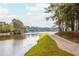 Scenic water view along a paved walking trail with lush green banks and autumn foliage at 1100 Muirfield Ct, Alpharetta, GA 30005