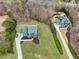 Aerial view of a home with a lush green yard, a garden, and mature trees at 2220 Stirling Bridge Rd, Cumming, GA 30041