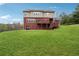 A view of the backyard with a walkout deck and lush green lawn at 2220 Stirling Bridge Rd, Cumming, GA 30041
