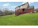 A view of the backyard with a walkout deck, a lush green lawn, and mature trees at 2220 Stirling Bridge Rd, Cumming, GA 30041