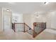 Hallway featuring wood and metal railing, plush carpet, and views to chandelier lit room at 2220 Stirling Bridge Rd, Cumming, GA 30041