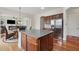 Open kitchen with granite island, stainless steel refrigerator, and view to the living area at 2220 Stirling Bridge Rd, Cumming, GA 30041