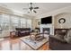 Cozy living room featuring a fireplace, hardwood floors, and large windows offering natural light at 2220 Stirling Bridge Rd, Cumming, GA 30041