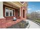 Close-up of the brick porch featuring a small fountain, landscaping, and an inviting entrance at 2220 Stirling Bridge Rd, Cumming, GA 30041