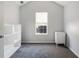 Bright bedroom with large window, neutral carpeting, and a minimalist white cabinet at 4419 White Rd, Douglasville, GA 30135