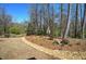 Serene backyard with mature trees and a rock-lined dry creek bed at 115 Dorys Way, Dallas, GA 30157