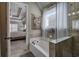 A tiled bathroom features a tub and shower with glass door that is next to the Primary bedroom at 115 Dorys Way, Dallas, GA 30157