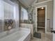 Well-lit bathroom with a walk-in shower and soaking tub next to an open closet at 115 Dorys Way, Dallas, GA 30157