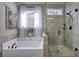 Elegant bathroom showcasing a glass door shower, a soaking tub, and a charming tapestry on the wall at 115 Dorys Way, Dallas, GA 30157