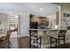 An open kitchen features dark wood cabinets, granite counters and stainless appliances with bar stool seating at 115 Dorys Way, Dallas, GA 30157