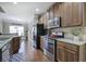 Kitchen features dark wood cabinets, stainless steel appliances, granite counters, and hardwood floors at 115 Dorys Way, Dallas, GA 30157