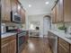 Gourmet kitchen features granite counters, stainless appliances, tile backsplash, and hardwood floors at 115 Dorys Way, Dallas, GA 30157