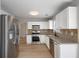 Modern kitchen featuring stainless steel appliances, white cabinets, and hardwood floors at 1196 Yellow River Dr, Lawrenceville, GA 30043