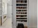 View of closet, full of shoes, leads to bathroom, with tiled floor and white cabinets at 1820 Peachtree Nw St # 303, Atlanta, GA 30309