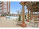 Inviting pool area features lounge chairs, tables, pergola, and a high rise brick building at 1820 Peachtree Nw St # 303, Atlanta, GA 30309