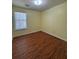 This bedroom features wood floors and a bright window at 257 Brookview Dr, Riverdale, GA 30274