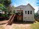 Home's back exterior, showing a deck, stairs, large windows, and backyard at 507 Autumn Walk, Canton, GA 30114