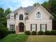 Charming two-story home featuring a well-maintained lawn, symmetrical shrubbery, and stone accents on the front entrance at 507 Autumn Walk, Canton, GA 30114