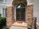 Arched doorway with sidelights and stone accents, featuring double doors with wreath decorations and a 'Hello' doormat at 507 Autumn Walk, Canton, GA 30114
