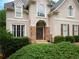 Inviting front entrance with double doors, stone detailing, manicured bushes, and a 'Welcome' sign at 507 Autumn Walk, Canton, GA 30114