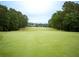 View of a well-maintained golf course showcasing a lush fairway, trees, and distant clubhouse at 507 Autumn Walk, Canton, GA 30114