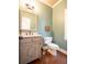 Well-appointed powder room with a stylish vanity, decorative mirror, and wood flooring at 507 Autumn Walk, Canton, GA 30114