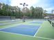 View of well-maintained blue tennis court with green surface at 507 Autumn Walk, Canton, GA 30114