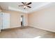 Large carpeted bedroom with ceiling fan and neutral paint, perfect for relaxation at 10670 Day Lily Dr, Hampton, GA 30228