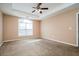 Spacious bedroom featuring a ceiling fan and large window allowing for plenty of natural light at 10670 Day Lily Dr, Hampton, GA 30228
