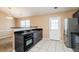 Modern kitchen featuring dark cabinets, stainless steel appliances, and tile flooring for easy maintenance at 10670 Day Lily Dr, Hampton, GA 30228