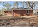 Rear view of red brick home with a spacious backyard and mature trees at 1207 Ellington Dr, Morrow, GA 30260