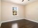 This bedroom features hardwood floors and a bright window with neutral-colored walls at 1207 Ellington Dr, Morrow, GA 30260