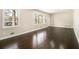 Bright living room with gleaming hardwood floors and large windows that bring in natural light at 1207 Ellington Dr, Morrow, GA 30260