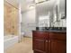 Bathroom with stone tile, dark vanity, and tub with shower at 195 14Th Ne St # 1908, Atlanta, GA 30309