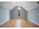 A sunlit bedroom featuring hardwood floors, a large window, and fresh paint at 10660 Thatcher Way, Johns Creek, GA 30097