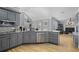 Open concept kitchen area with stainless steel appliances and gray cabinets at 10660 Thatcher Way, Johns Creek, GA 30097