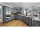 Modern kitchen featuring gray cabinetry, granite countertops, and stainless appliances at 10660 Thatcher Way, Johns Creek, GA 30097