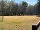 Community recreation field with ample space for activities and outdoor enjoyment with surrounding trees at 10660 Thatcher Way, Johns Creek, GA 30097