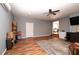 Open living area features wood floors, a modern ceiling fan, a tv and multiple entry and access points at 11555 Brown Bridge Rd, Covington, GA 30016